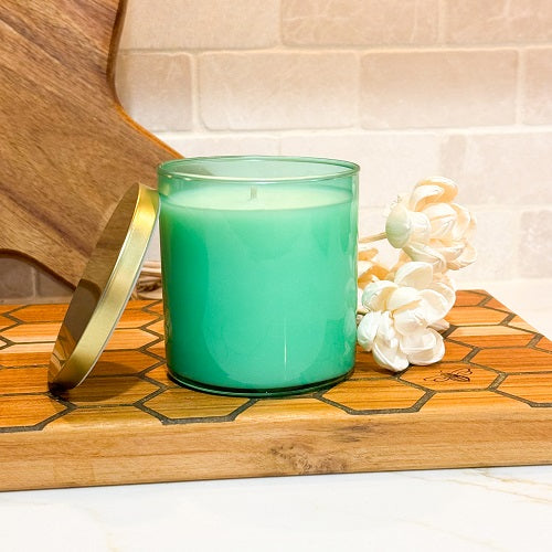 hand poured scented soy candle in sea foam green glass jar with a gold lid 
